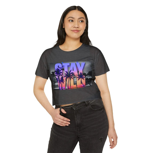 Woman wearing a grey crop top with a colorful 'Stay Wild' graphic design on a white background