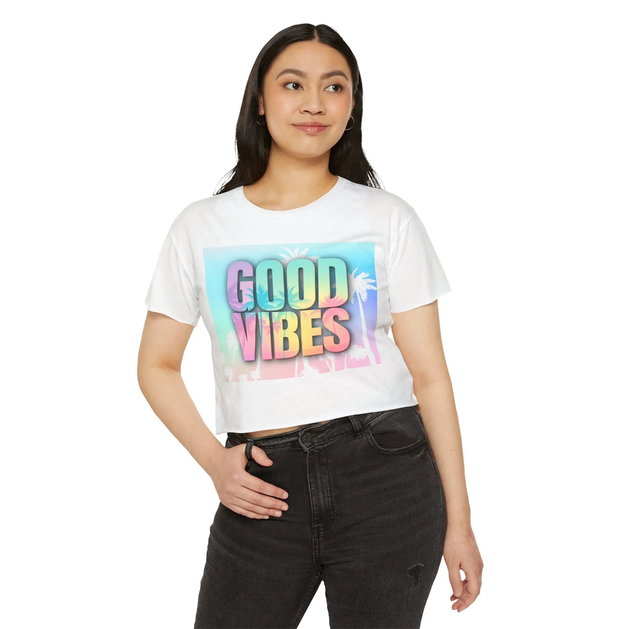 Woman wearing a white crop top with 'Good Vibes' print on a white background