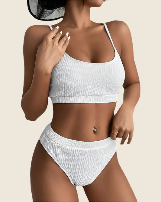 Woman wearing a white bikini set on a beige background