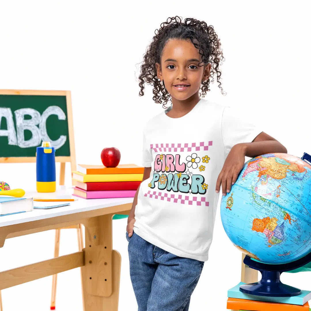 Child wearing a 'Girl Power' shirt standing next to a globe in an educational setting