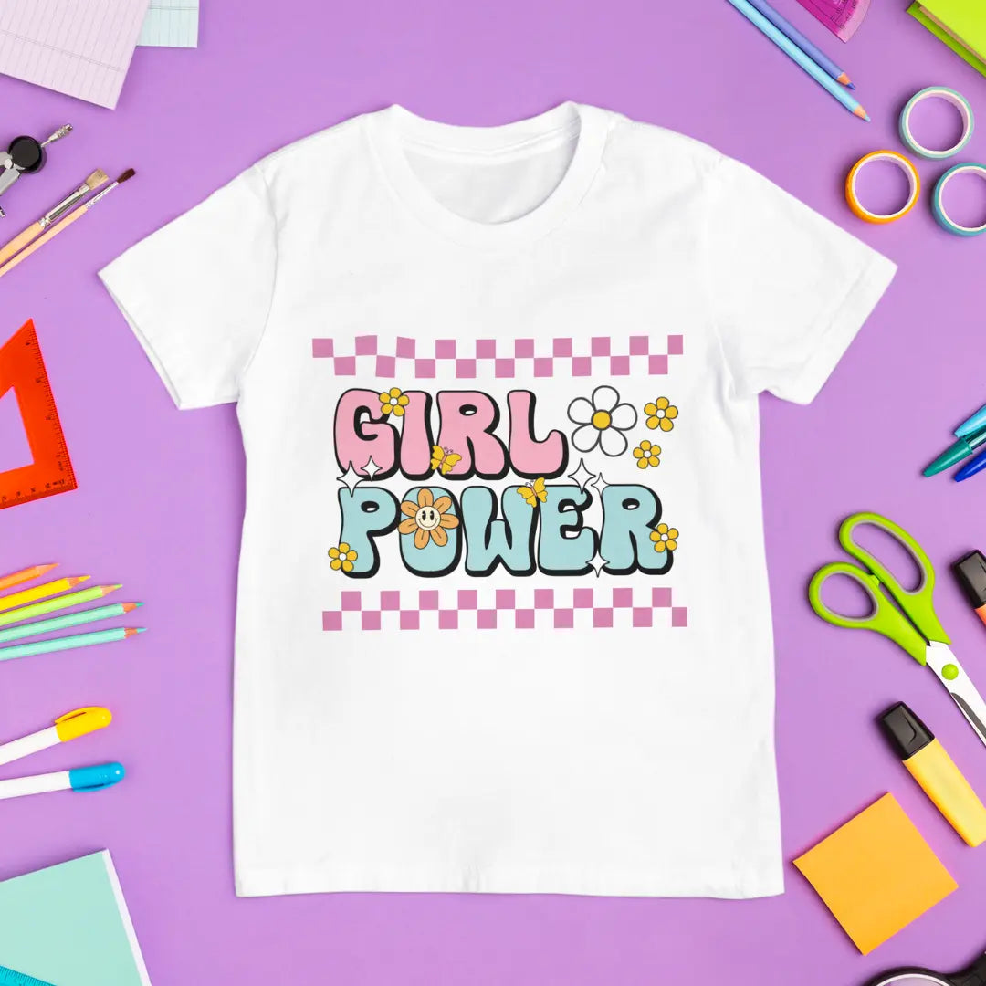 White t-shirt with 'Girl Power' text on a purple background with stationery items.