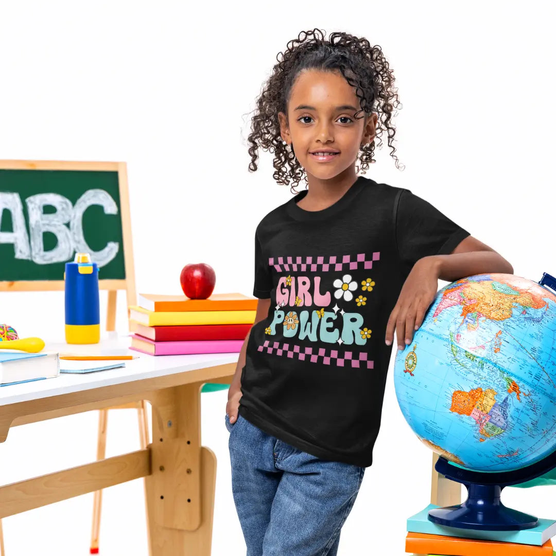 Child wearing a 'Girl Power' shirt in an educational setting with books and a globe.