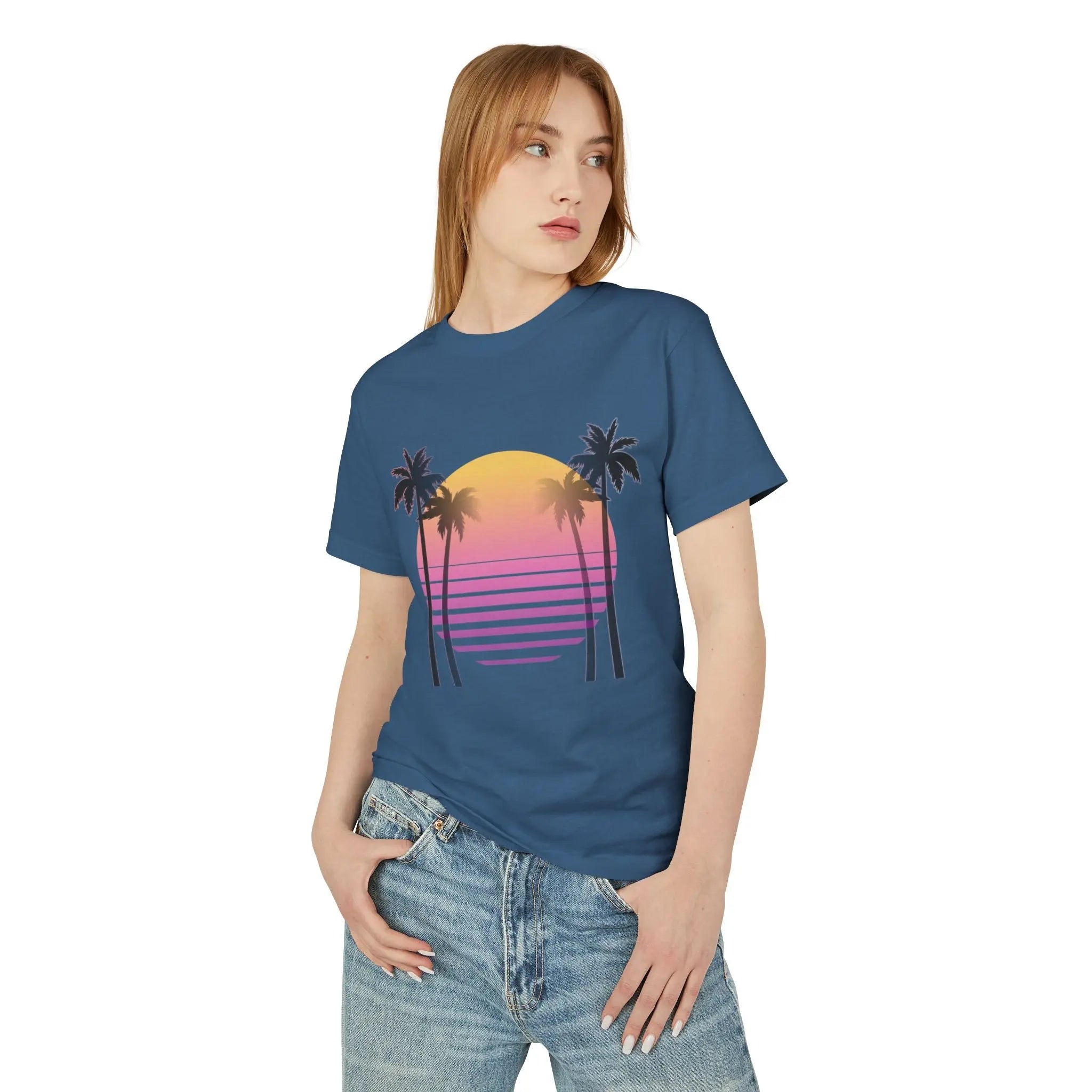 Person wearing a blue t-shirt with a palm tree and sunset design on a white background