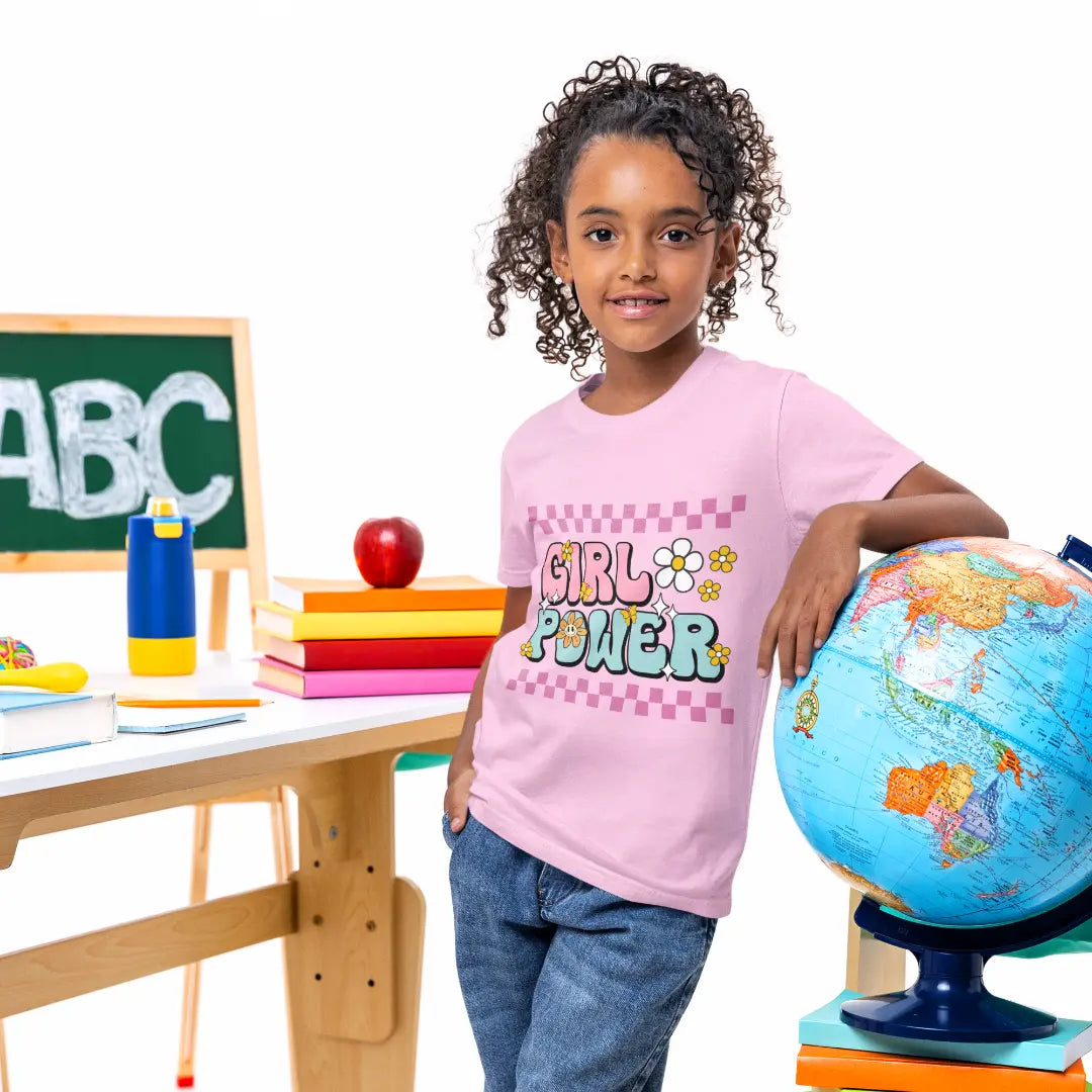 Child wearing a 'Girl Power' shirt standing next to a globe in an educational setting