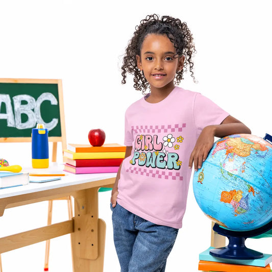 Child wearing a 'Girl Power' shirt standing next to a globe in an educational setting