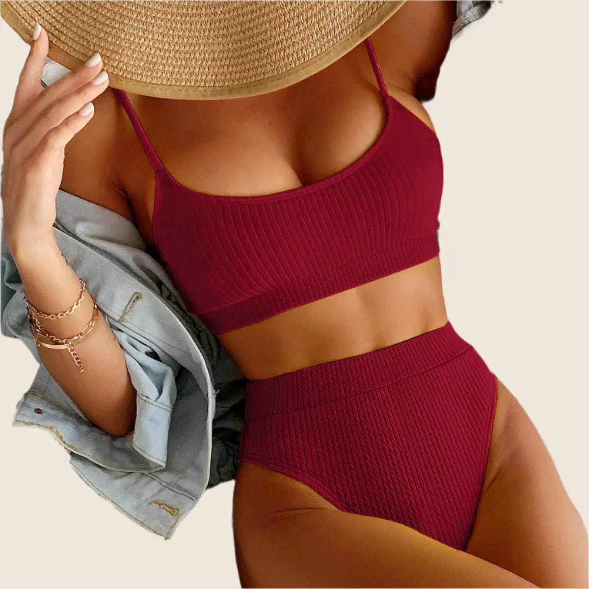 Person wearing a red bikini and straw hat on a neutral background