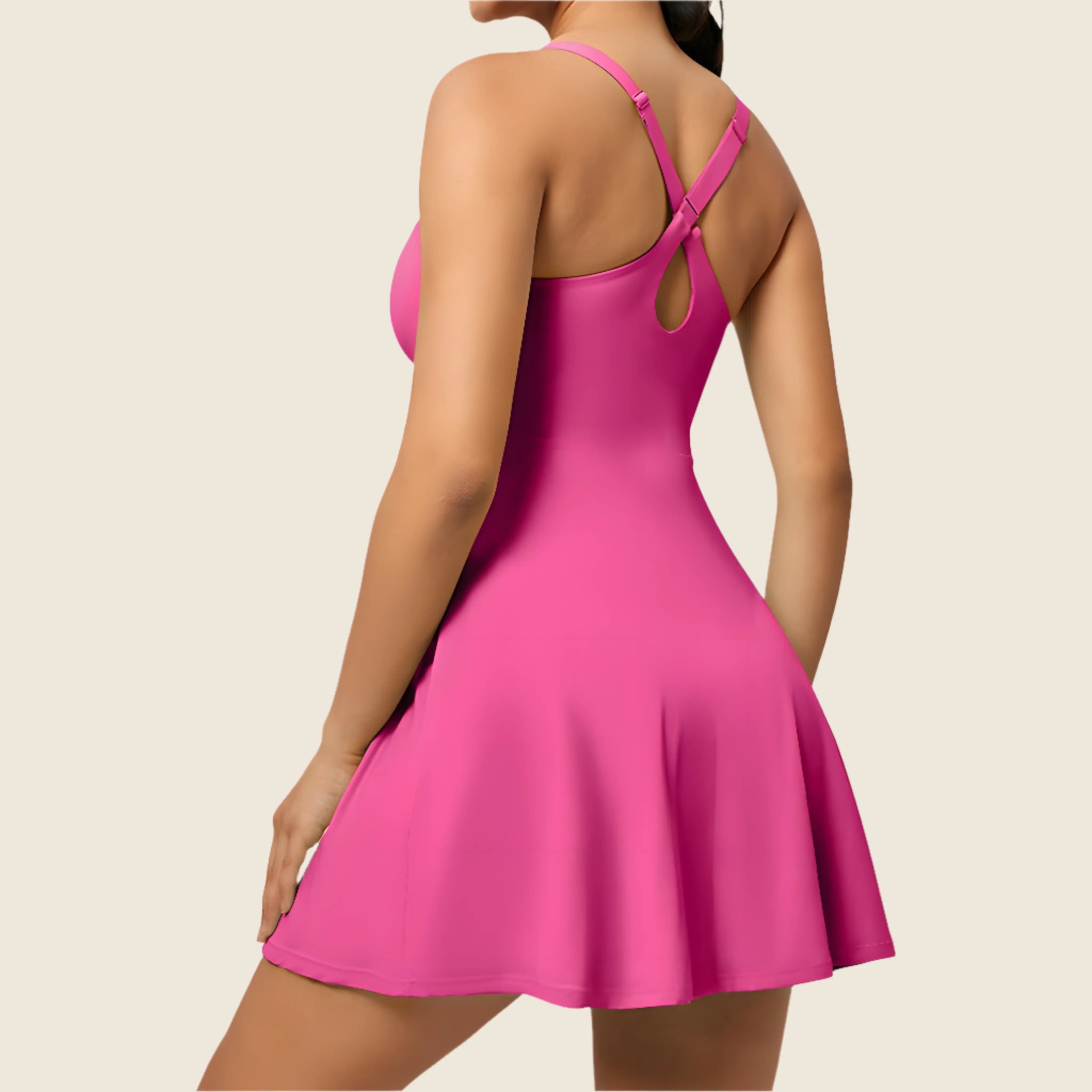 Pink dress with thin straps and cut-out back on a beige background