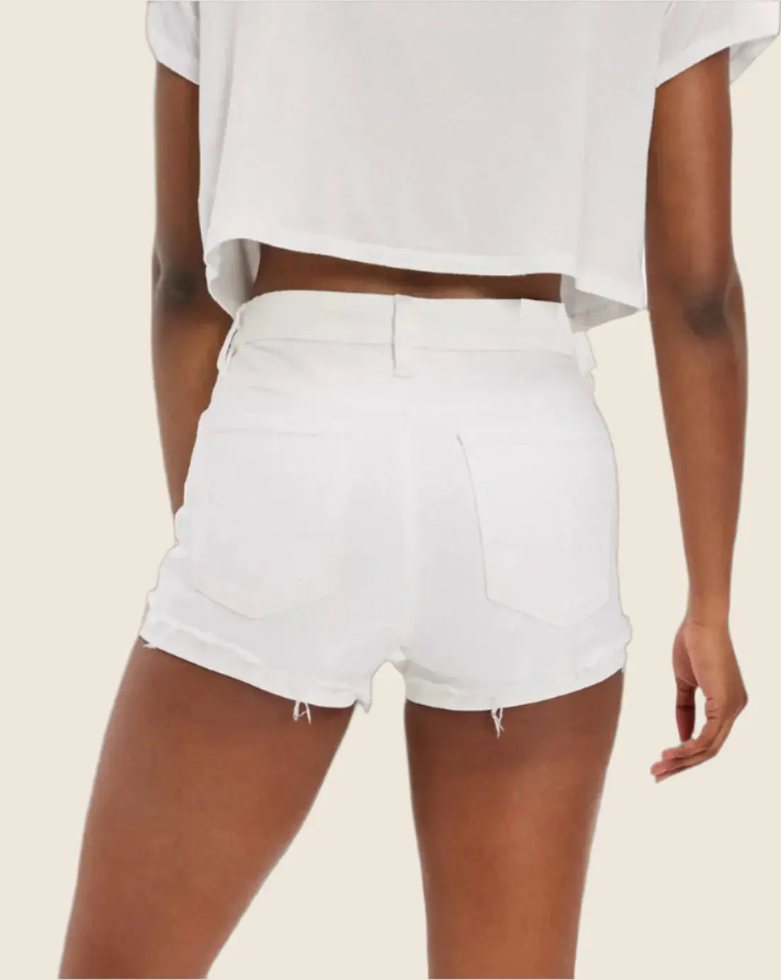 White shorts worn by a person on a beige background